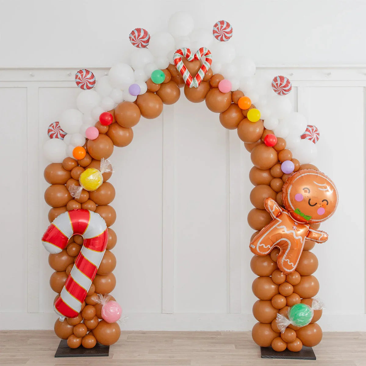Christmas balloon arch with gingerbread man, candy canes, and colorful sweets decoration