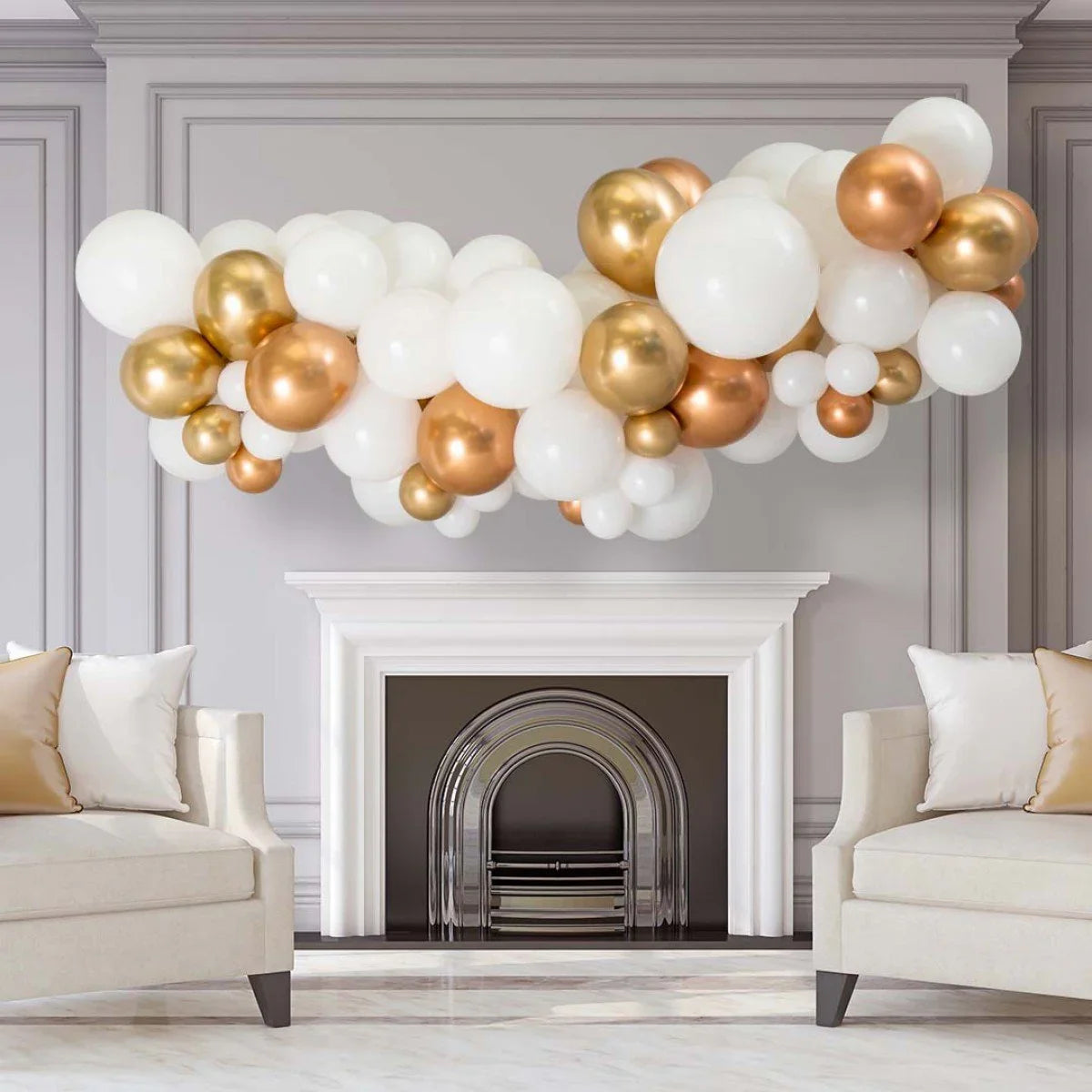 White, copper, and gold chrome balloon garland decoration above a white fireplace in a modern living room