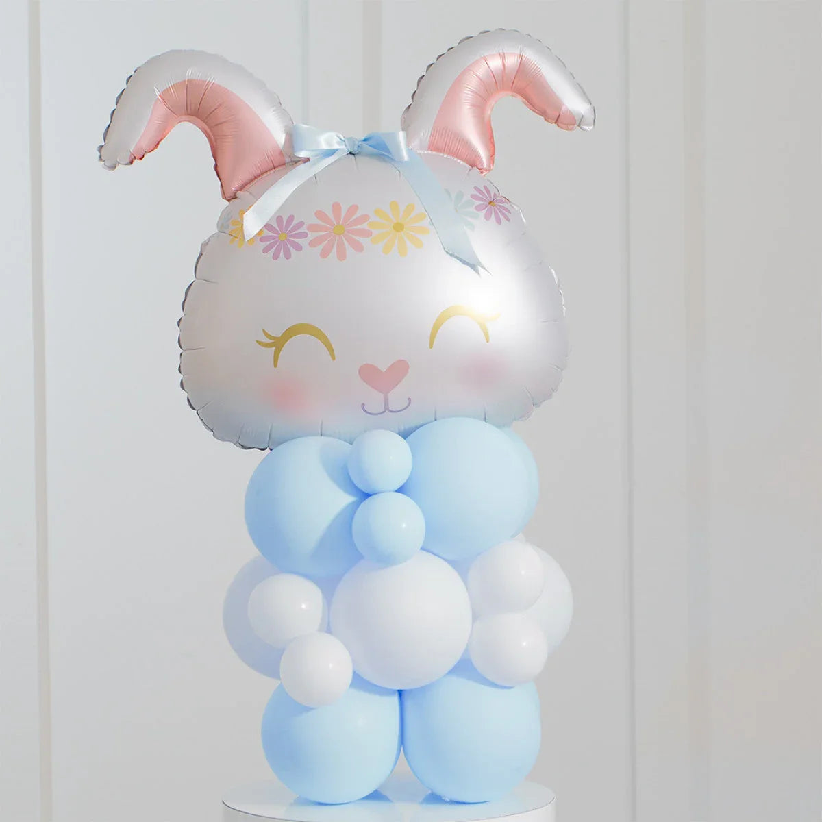 Easter bunny balloon decoration with pink ears, floral headband, blue and white balloons