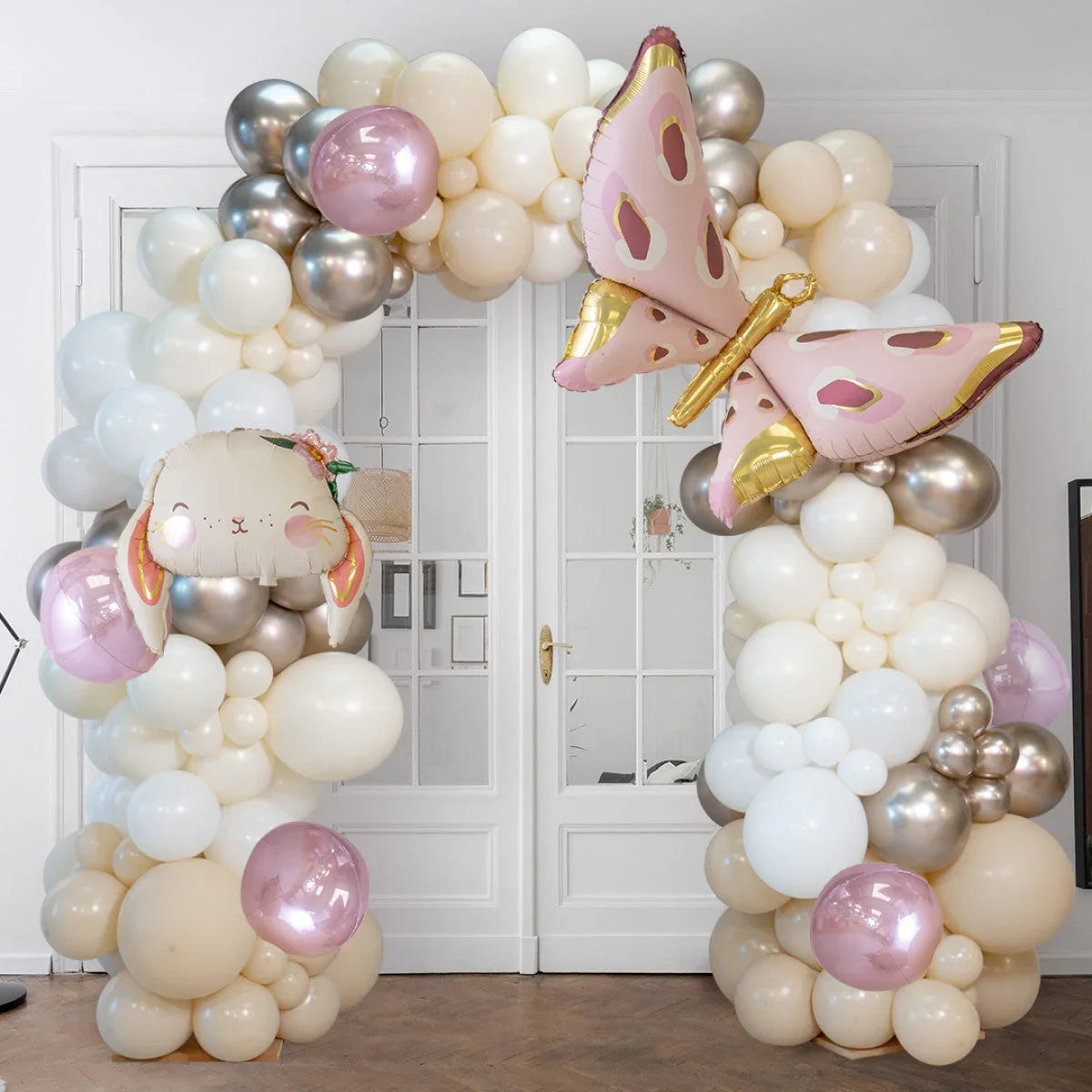 Decorative balloon arch with pearl white, beige, pink, silver balloons and bunny and butterfly foil balloons