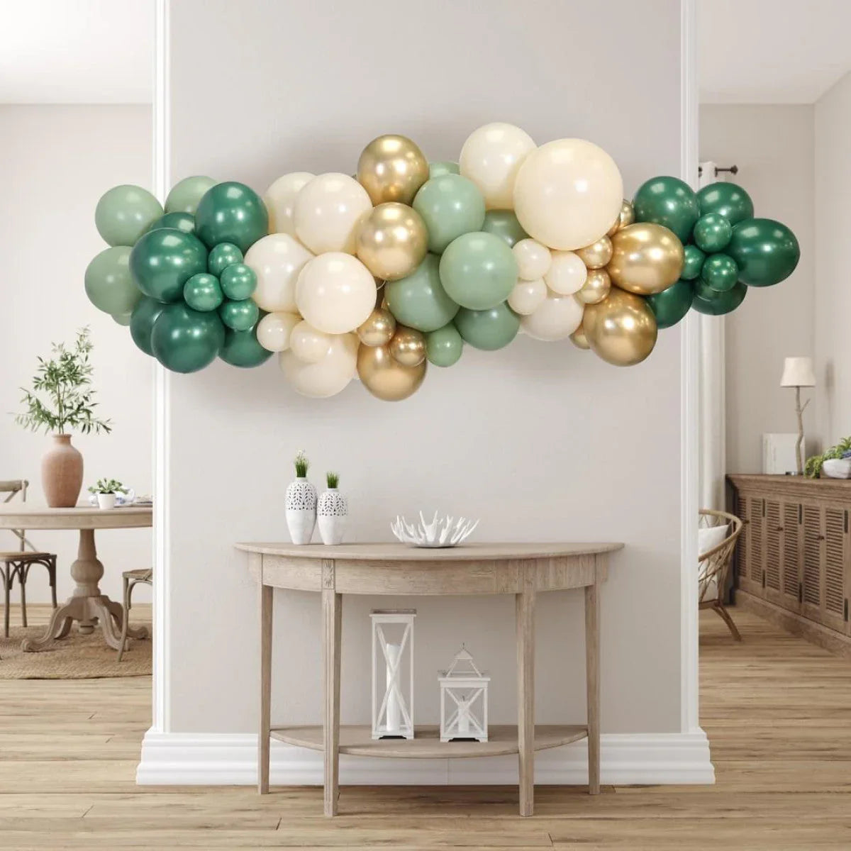 Green, white, and gold balloon garland decoration above wooden console table in modern room