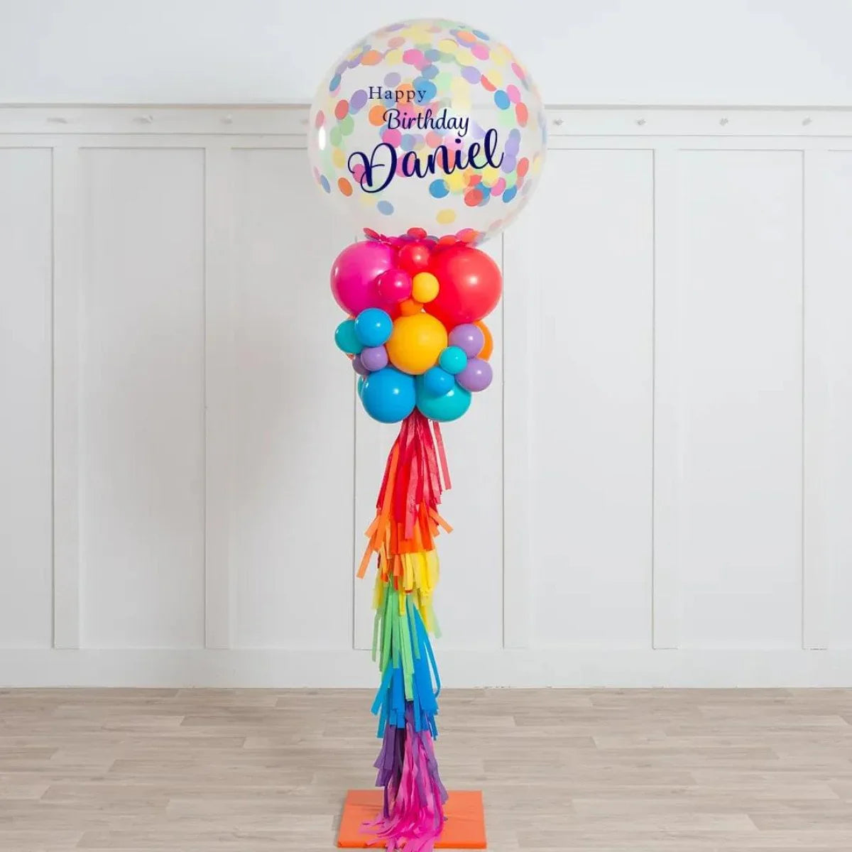 Happy Birthday Daniel clear balloon with colorful confetti and rainbow balloon pillar decoration