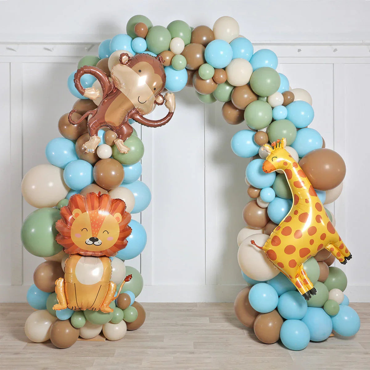 Safari-themed balloon arch with lion, monkey, and giraffe foil balloons in blue, green, and brown colors