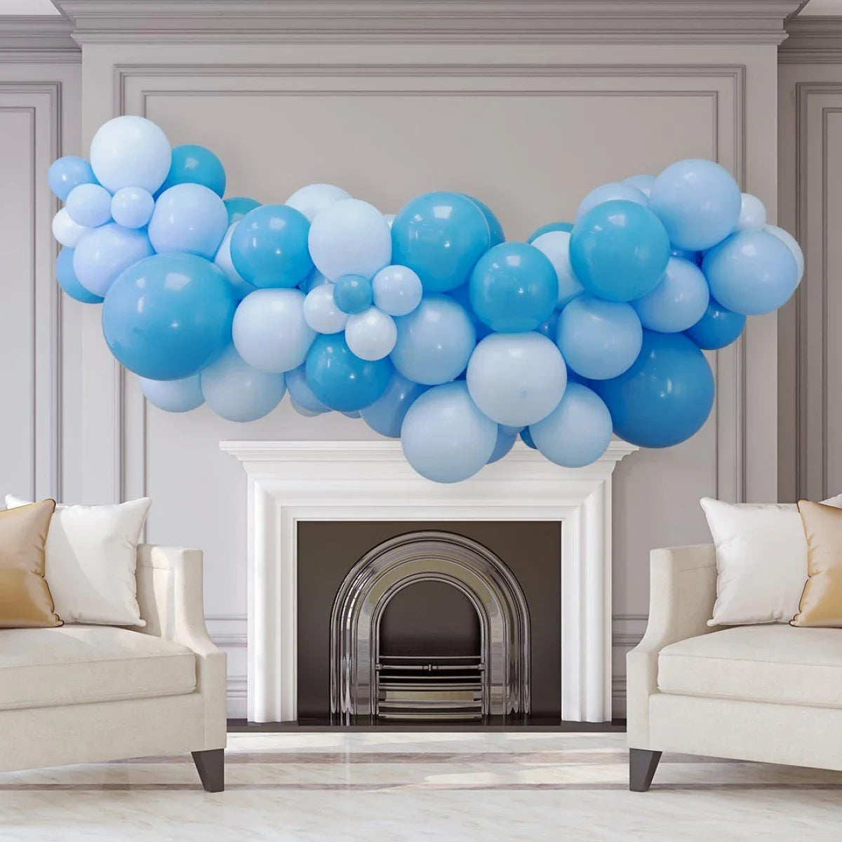 Blue and light blue balloon garland decoration above white fireplace in modern living room
