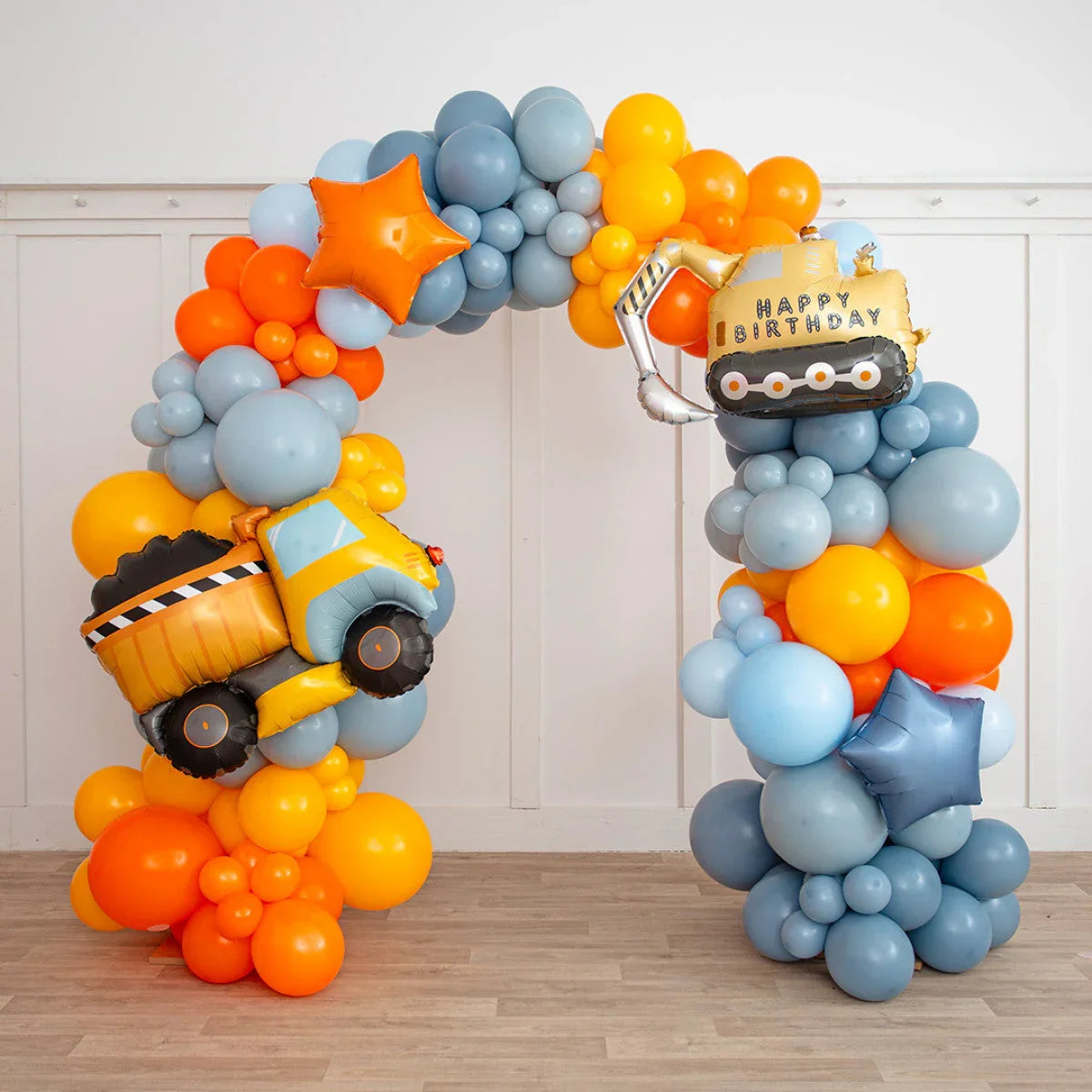 Colorful balloon arch with orange, blue balloons and construction truck-shaped birthday balloons