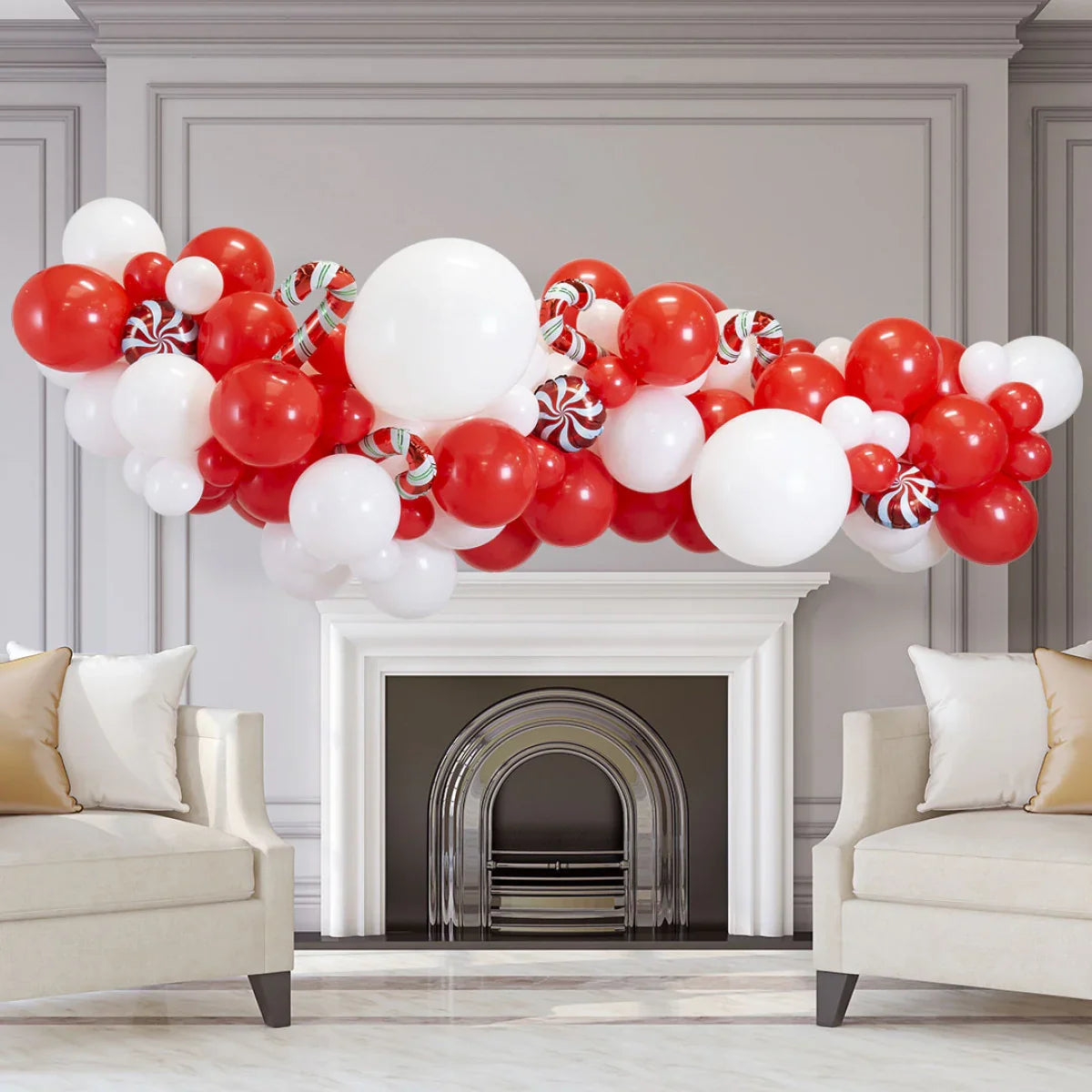 Red and white Christmas balloon garland with candy canes above white fireplace in living room