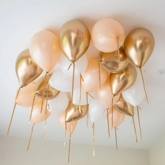 Cream chrome helium balloons on ceiling, gold, peach and white party decor in Dubai