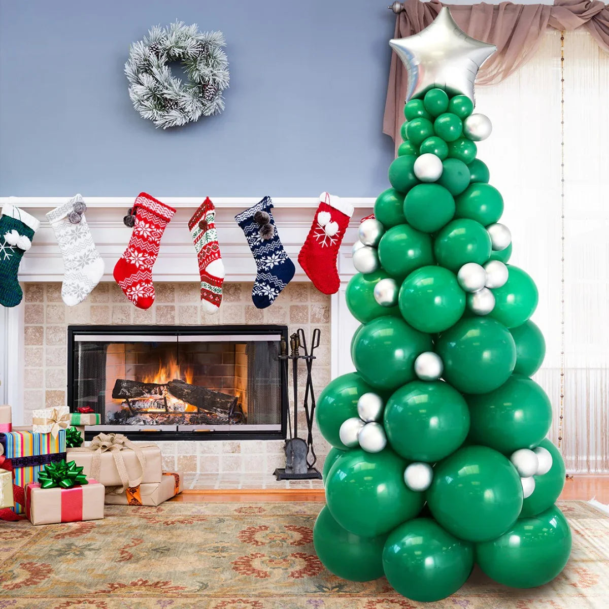Festive green and silver balloon Christmas tree with fireplace, stockings, and gifts in living room