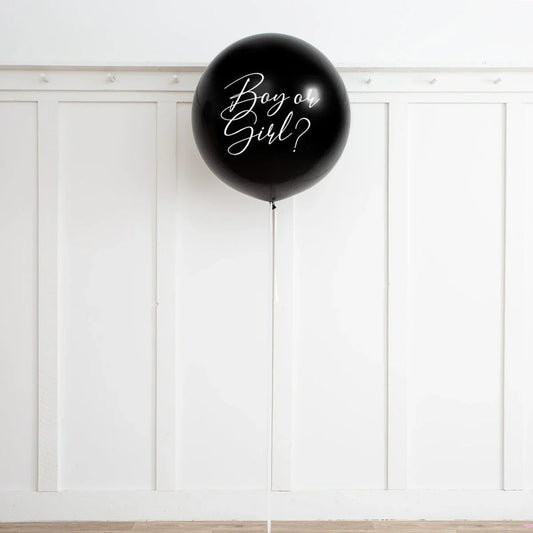 Large black gender reveal balloon with 'Boy or Girl?' text against white wall