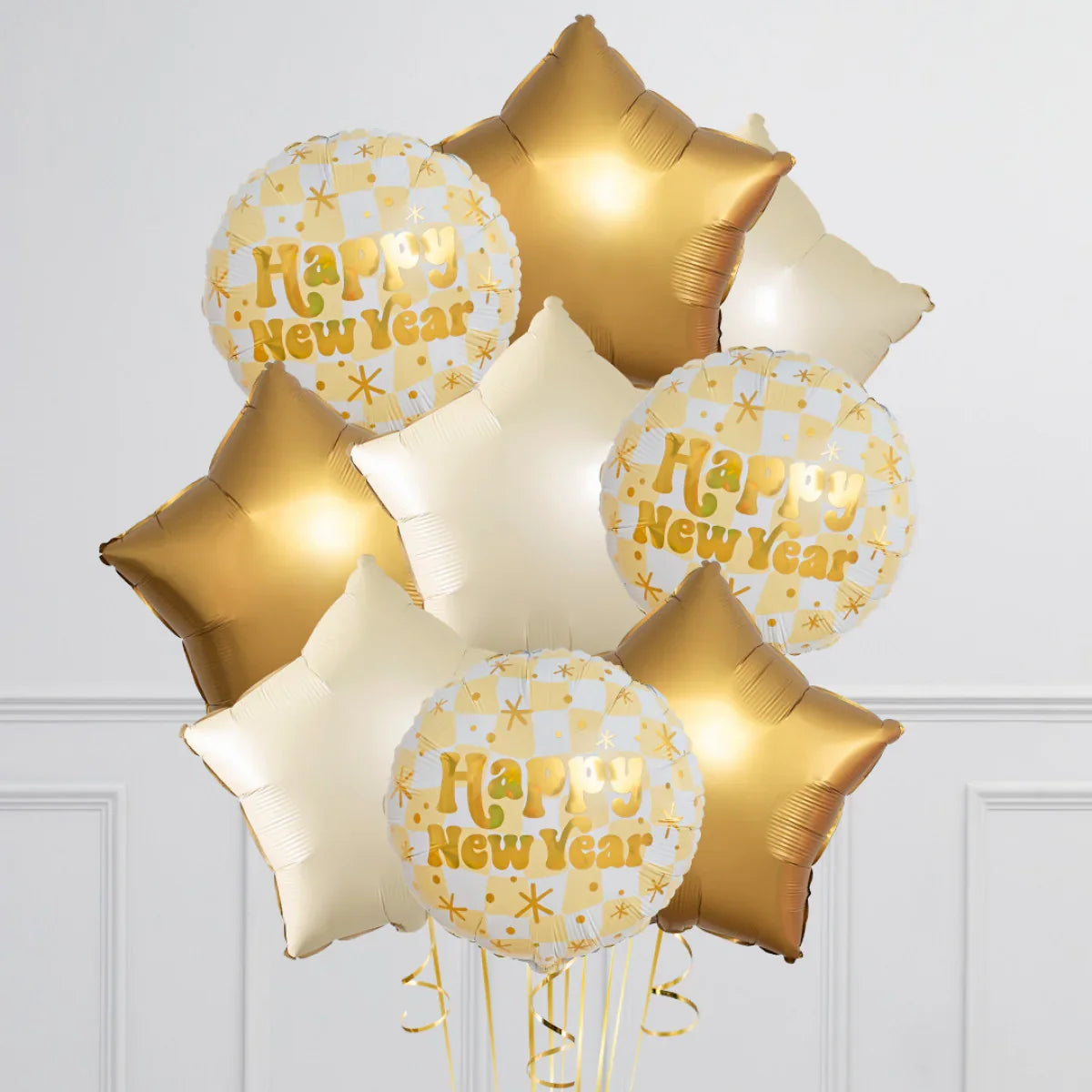 Gold and white star and round foil balloons with Happy New Year text in an elegant indoor setting