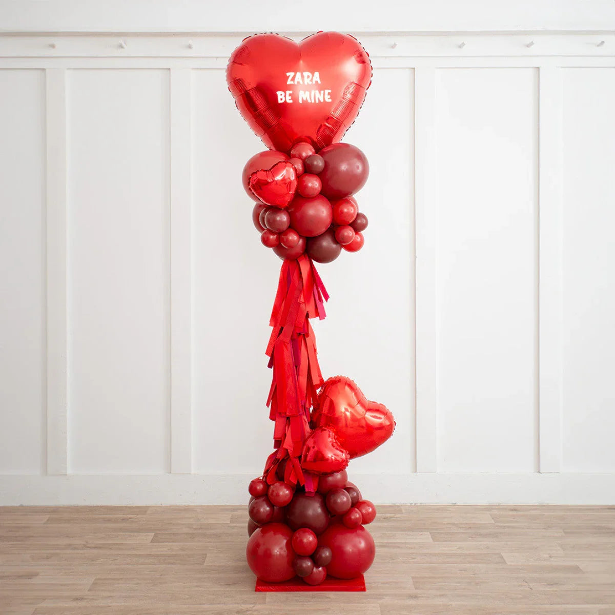 Heart-shaped red balloon arrangement with 'ZARA BE MINE' text, Dubai party decor