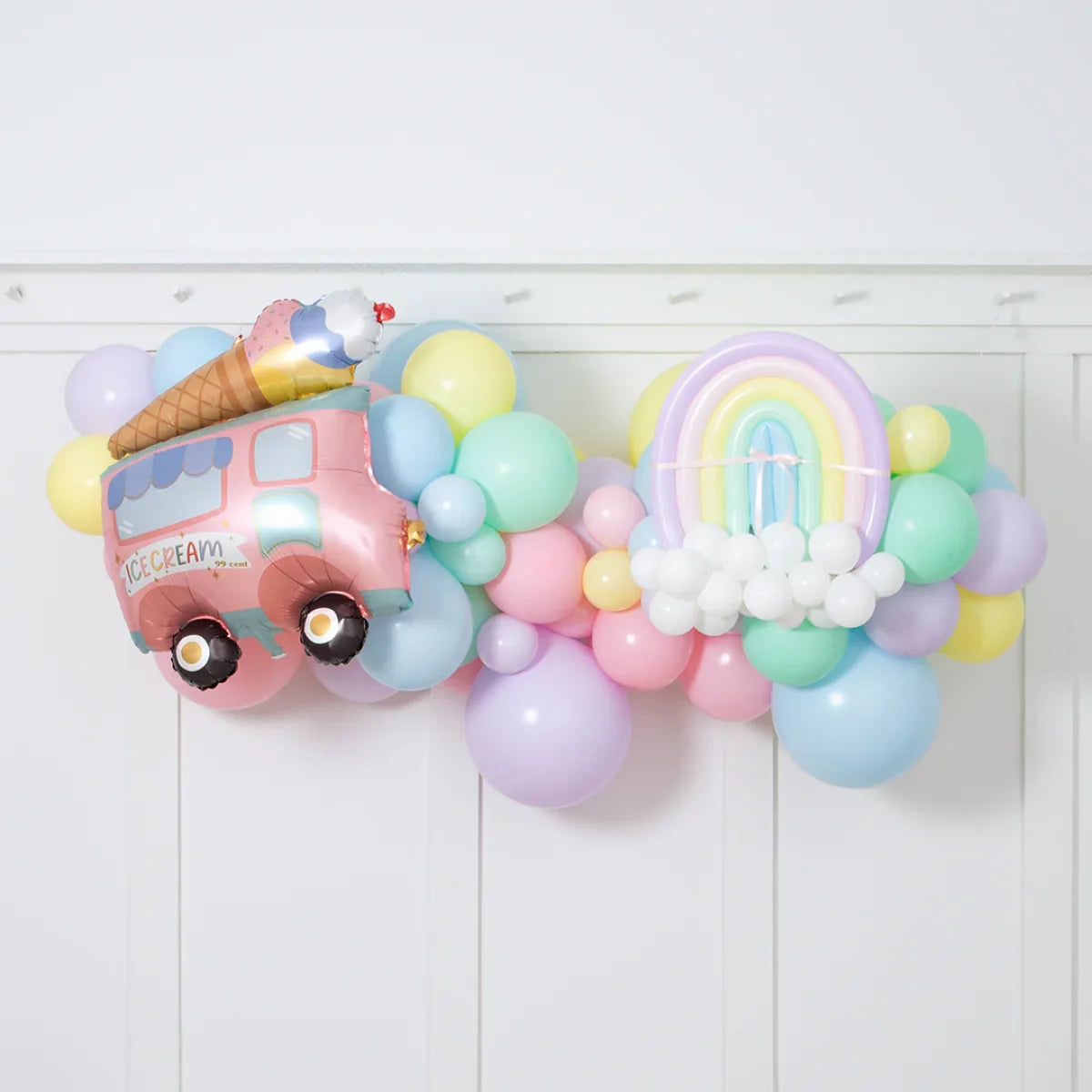 Pastel balloon garland with ice cream truck and rainbow foil balloons for party decoration