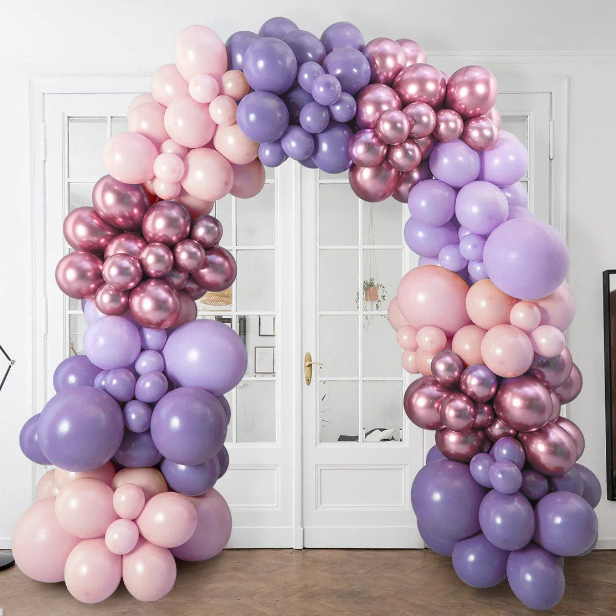 Lavender and rose metallic balloon arch decoration in front of white double doors indoors
