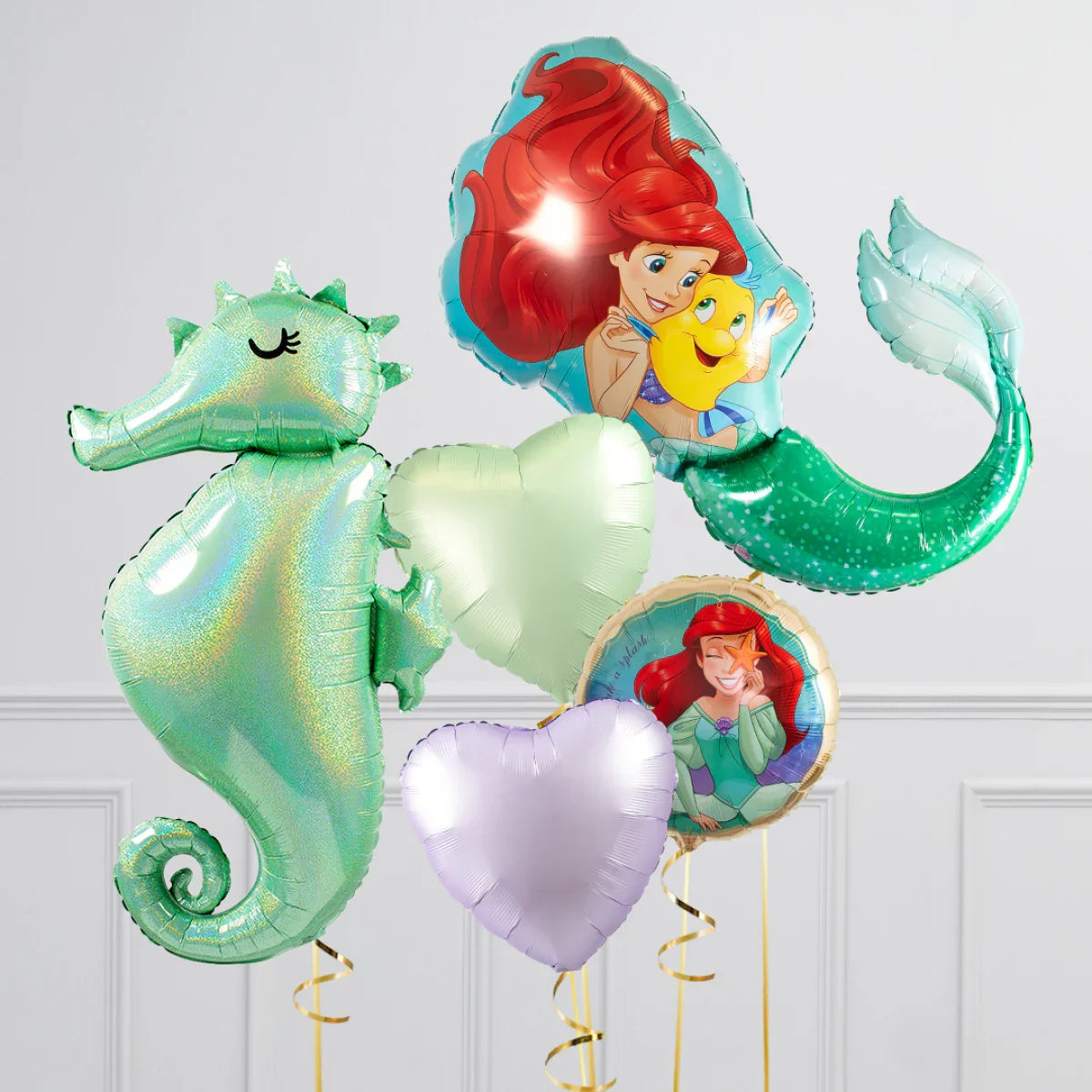 Colorful Disney Little Mermaid foil balloons including Ariel with Flounder, seahorse, and heart shapes