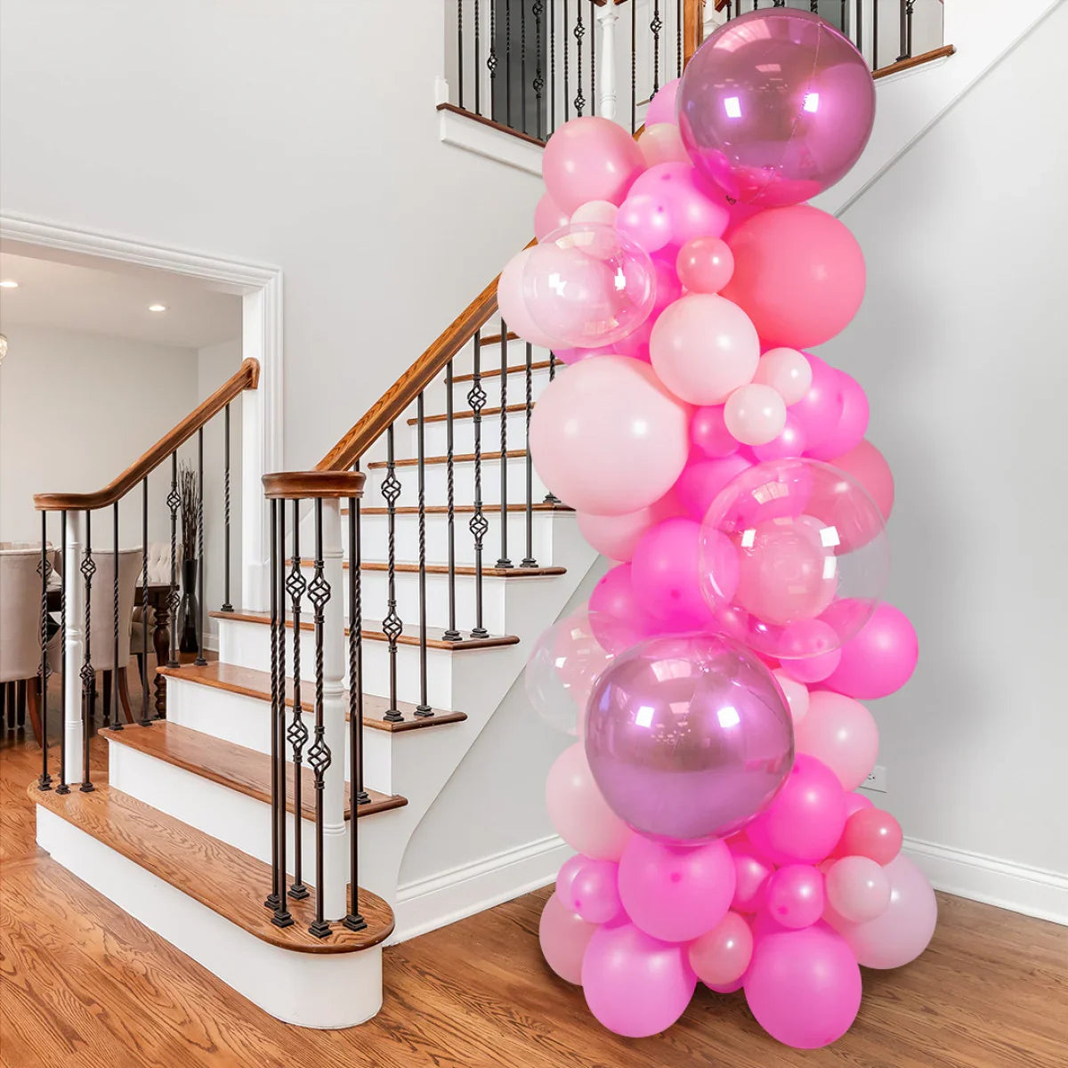 Pink balloon pillar decoration with various shades of pink balloons by indoor staircase