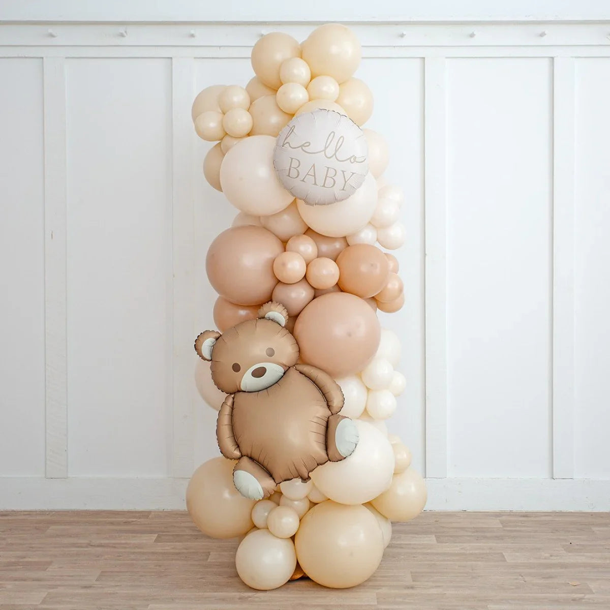 Neutral beige balloon pillar with teddy bear and 'hello BABY' balloons for baby shower decoration