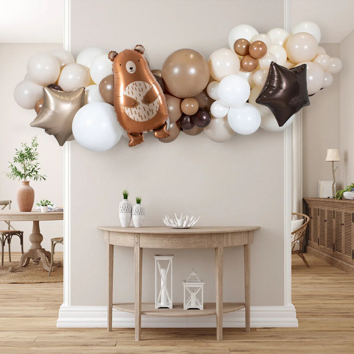 Neutral baby bear foil balloon party garland with white, brown, and gold balloons over wooden table