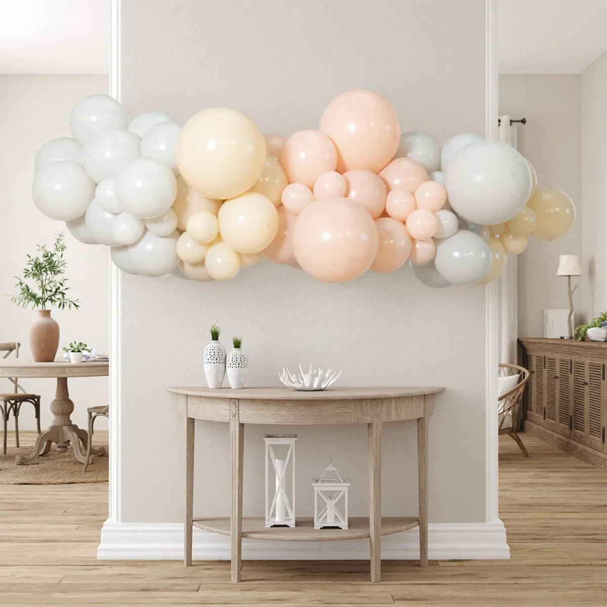 Nude and blush balloon garland decoration above wooden console table in modern home interior