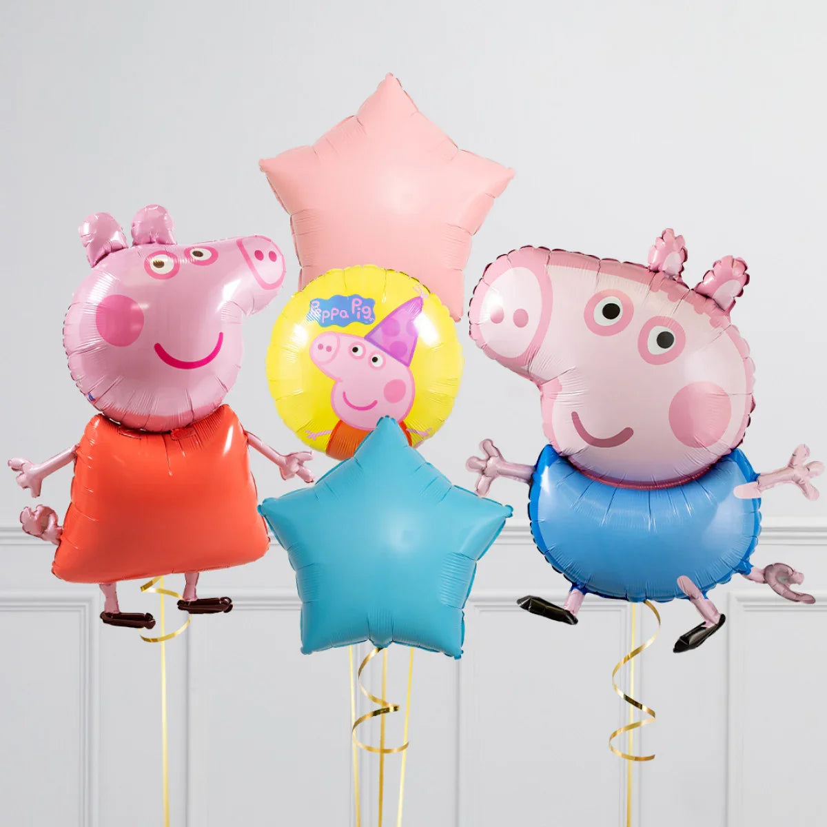 Peppa Pig and George character foil balloons with pink and blue star-shaped balloons in a white room