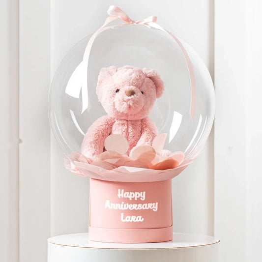 Personalised pink teddy bear in a clear bubble gift box with 'Happy Anniversary Lara' text