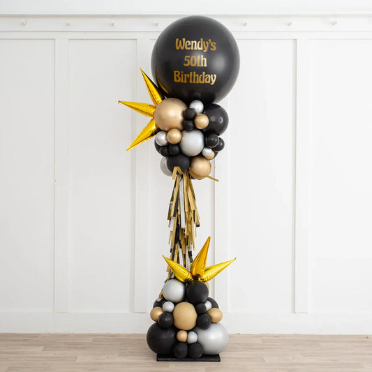 Black, gold, and silver balloon arrangement with gold spikes and text 'Wendy's 50th Birthday' for party decoration