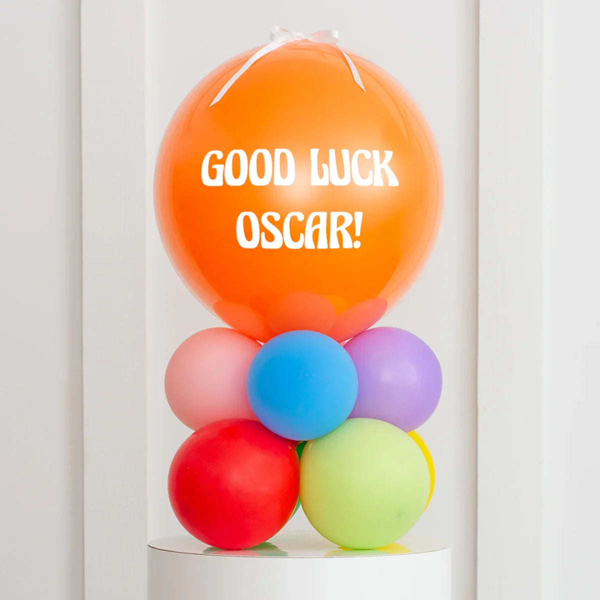 Personalized orange bubble balloon with 'Good Luck Oscar!' text on colorful balloon base