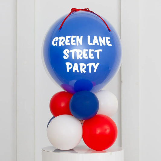 Red, white, and blue balloon stack with large balloon displaying Green Lane Street Party text