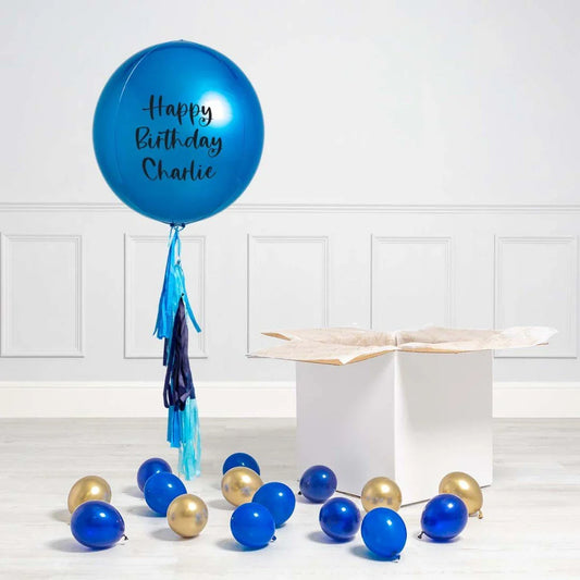 Personalized sapphire blue orb birthday balloon with tassels, gold and blue balloons, open box