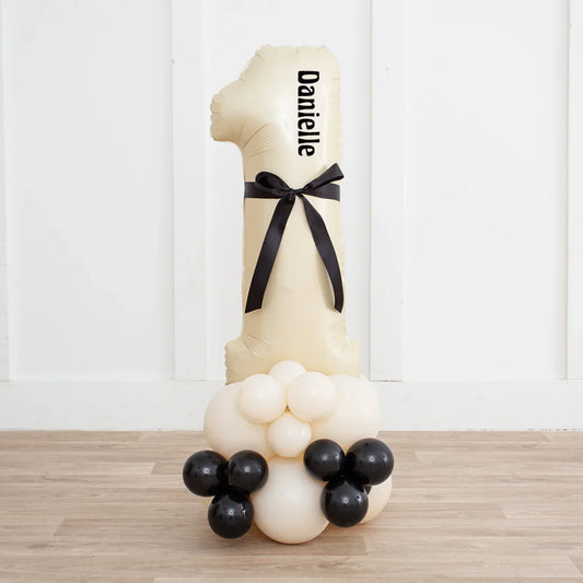 Personalized number one ivory balloon stack with black ribbon and black, white balloons