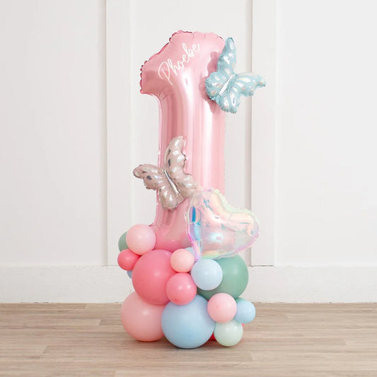 Pink number 1 balloon stack with butterflies and pastel balloons for birthday party decoration