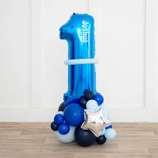 Personalized deep blue number 1 balloon decorated with smaller blue and silver star balloons on wooden floor
