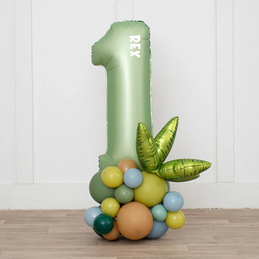 Personalized green number one dinosaur balloon stack with tropical balloons on wood floor