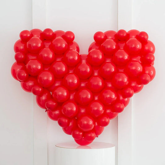 Red balloon mosaic in heart shape against white background