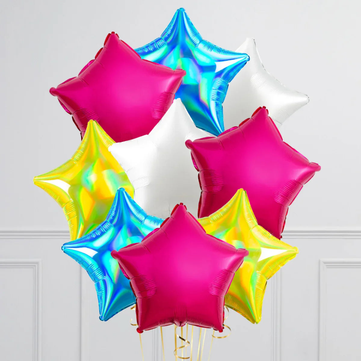Colorful star-shaped foil balloons in pink, blue, yellow, and white against white wall