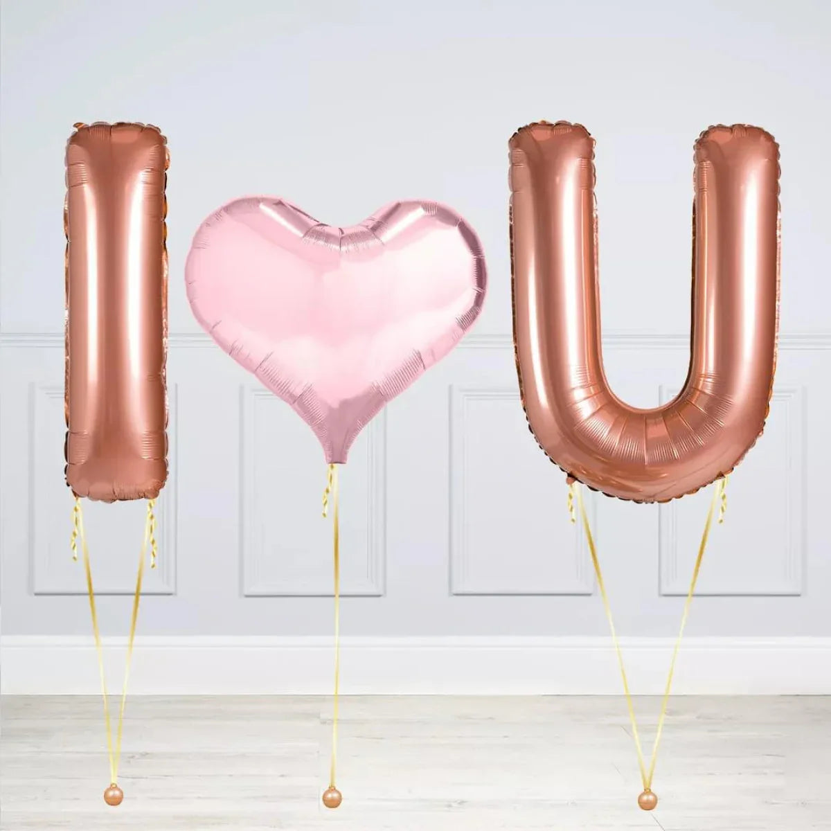 Rose gold and pink heart-shaped foil balloons spelling I love U for romantic decoration