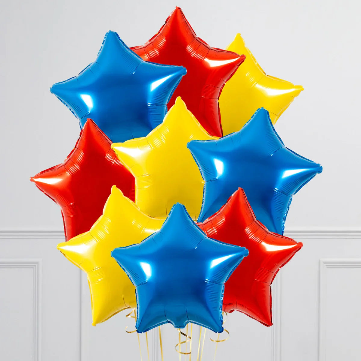 Cluster of shiny red, blue, and yellow star-shaped foil balloons on white background