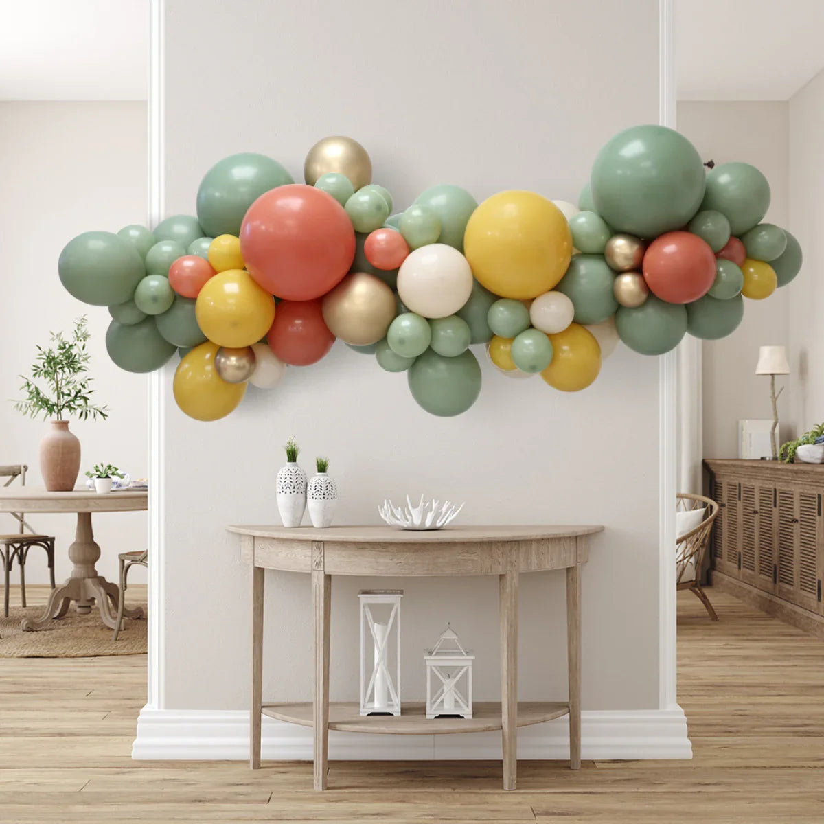 Decorative balloon garland in green, orange, yellow, white, and gold above a wooden console table in a modern living room