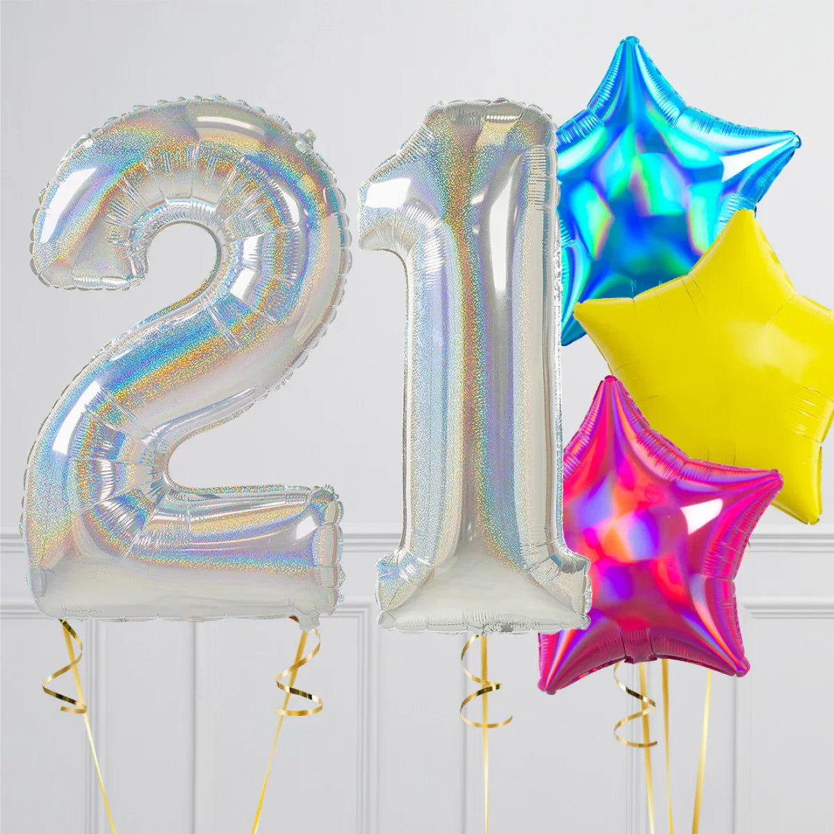 Silver holographic number 21 balloons with colorful star-shaped foil balloons on white wall background