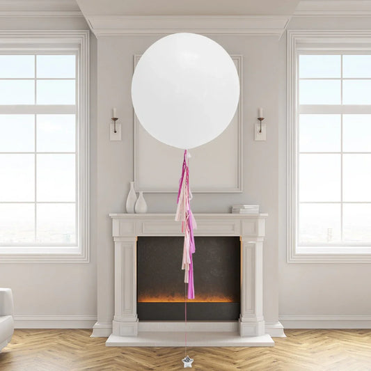 White balloon with pink and cream tassel near fireplace in modern Dubai living room