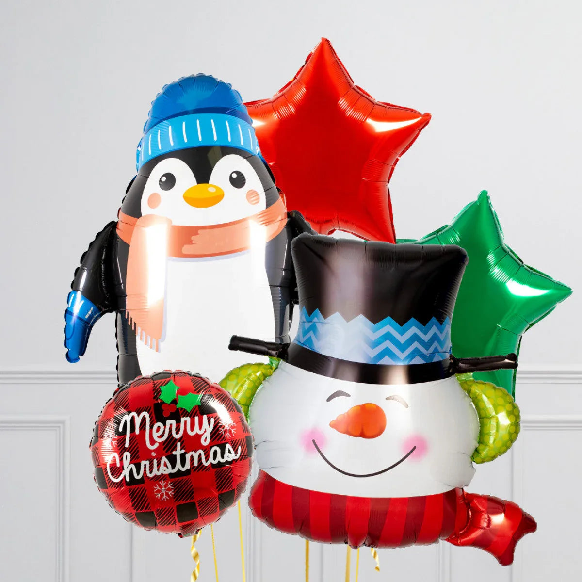 Christmas balloons featuring a penguin with blue hat, smiling snowman with top hat, red and green star balloons, and Merry Christmas balloon