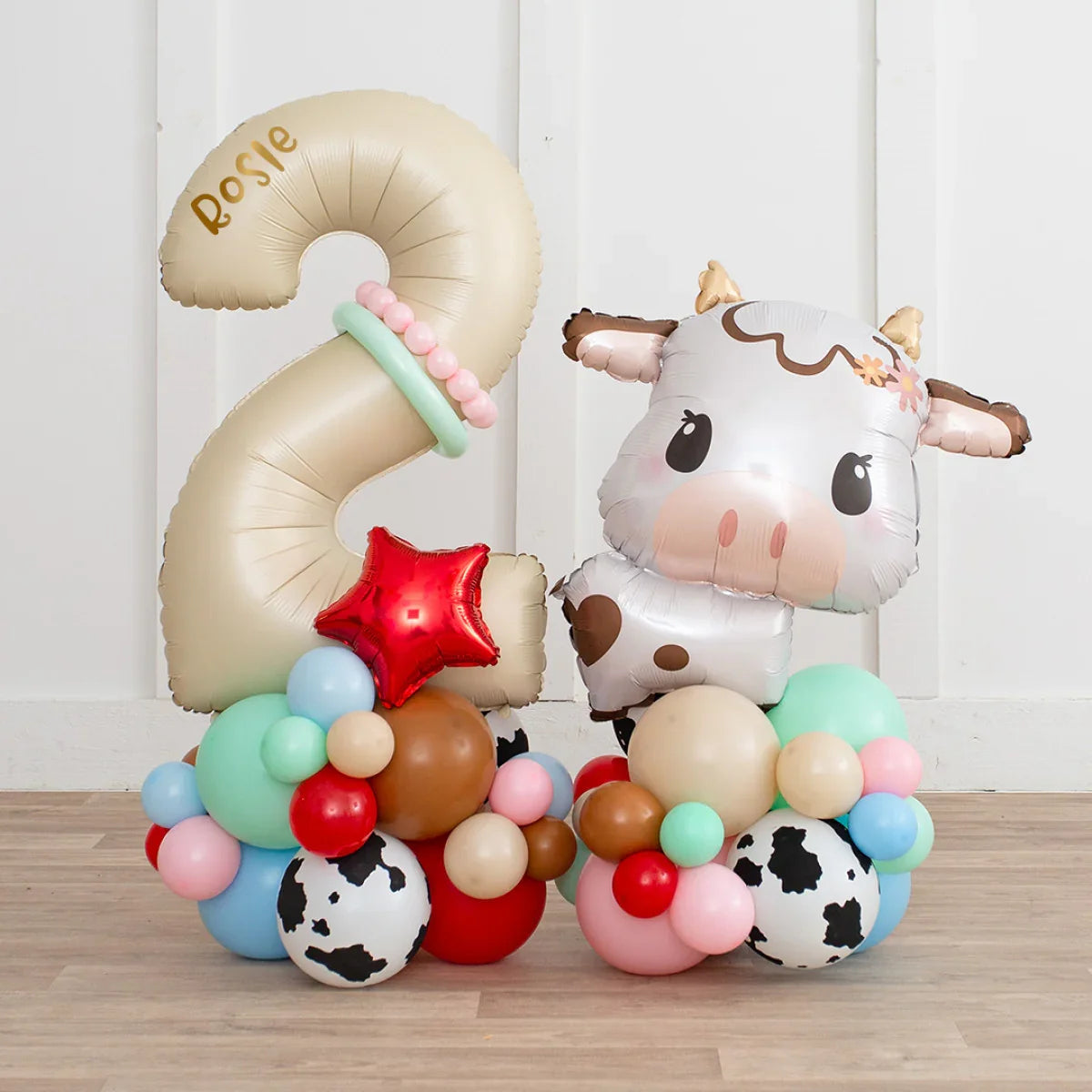 Personalized gold number 2 balloon with name Rosie and cow-shaped foil balloon decoration