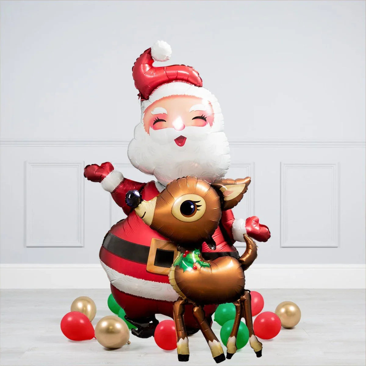 Festive foil balloons shaped as smiling Santa Claus and a reindeer with red, green, and gold balloons on floor