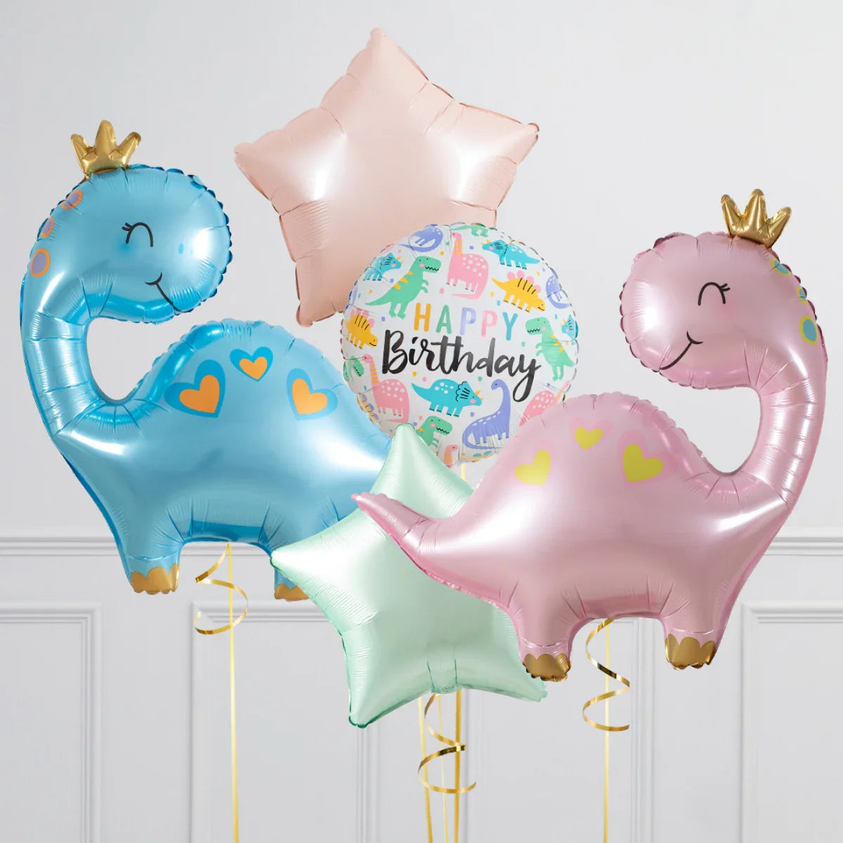 Colorful happy birthday balloons including blue and pink dinosaur shapes with crowns and star-shaped helium balloons