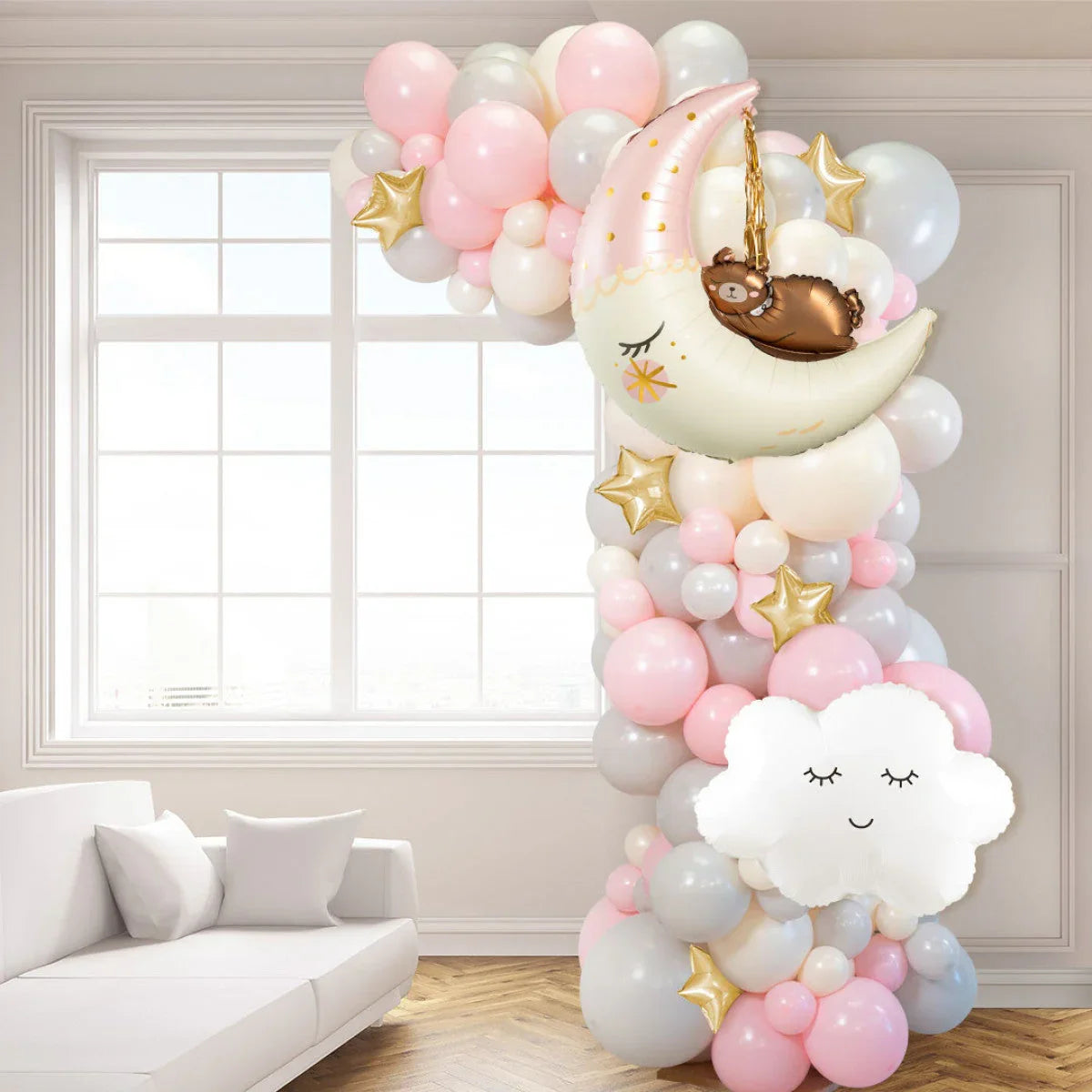 Pink and gray balloon garland with moon, bear, star, and cloud balloons in bright living room