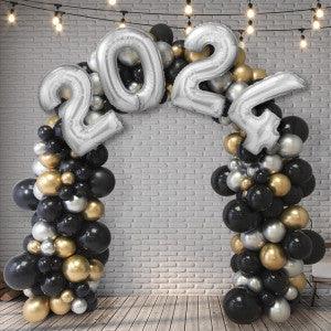 2024 prom balloon arch with black, gold, and silver balloons in front of white brick wall
