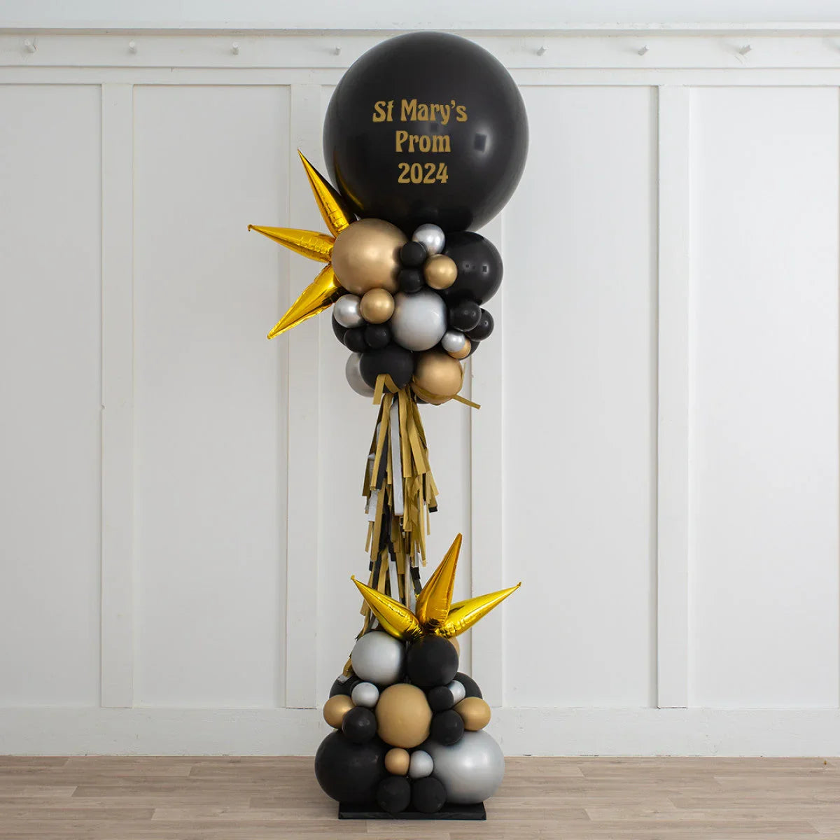 Elegant prom balloon pillar with black, gold, and silver balloons and gold star accents