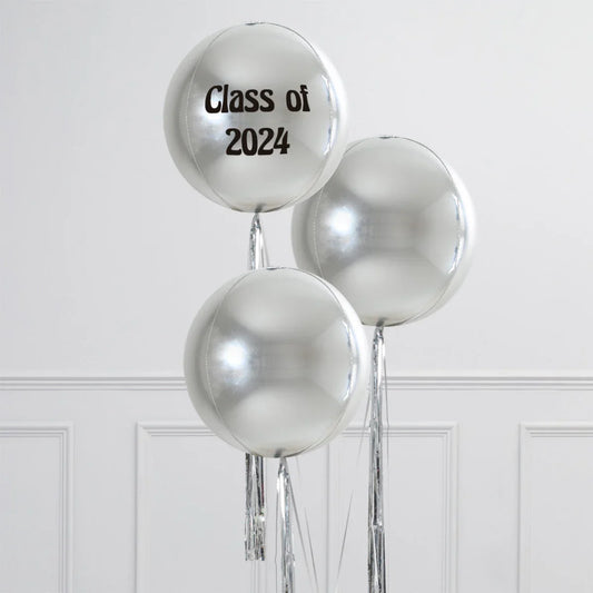 Silver graduation balloons with 'Class of 2024' text, white wall background