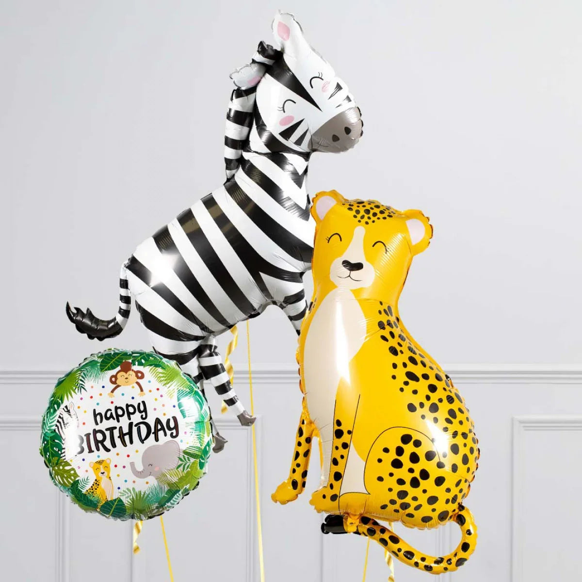Safari-themed happy birthday balloons featuring smiling zebra, cheetah, and animal print designs