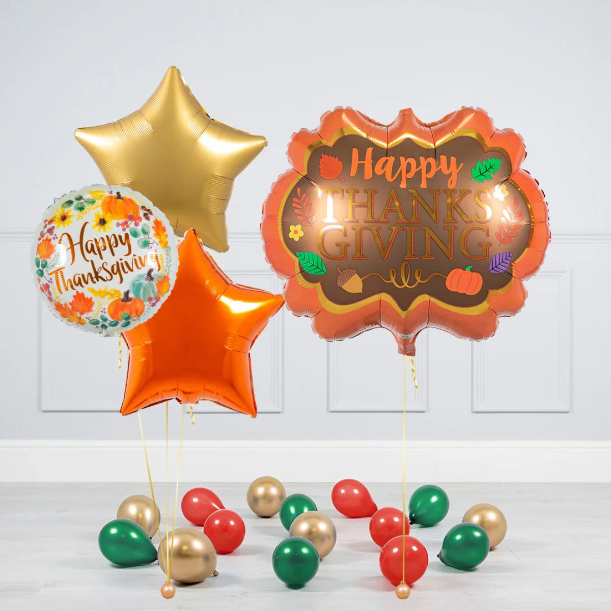 Happy Thanksgiving foil balloons in autumn colors with scattered red, green, and gold latex balloons on floor