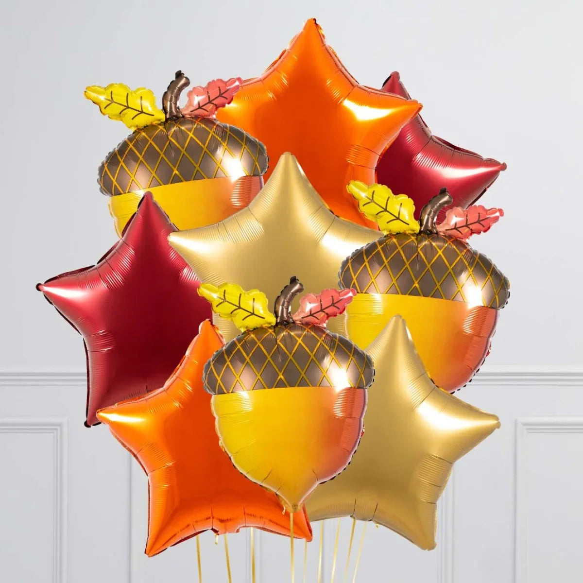 Fall-themed helium balloons in acorn and star shapes with autumn colors red, orange, and gold